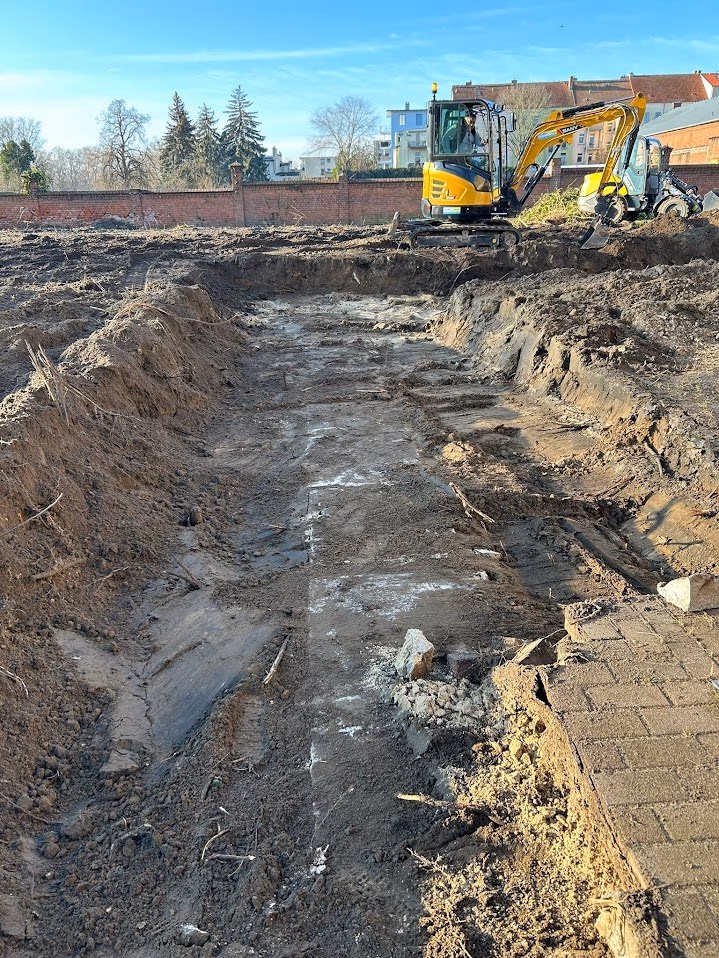 Bagger hebt eine große Baugrube aus, Erdaushub auf Halde daneben