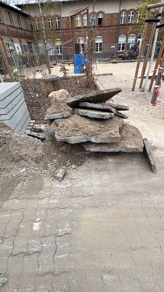 Aufgebrochene alte Betonplatten auf der Hoffläche, zum Abtransport gestapelt