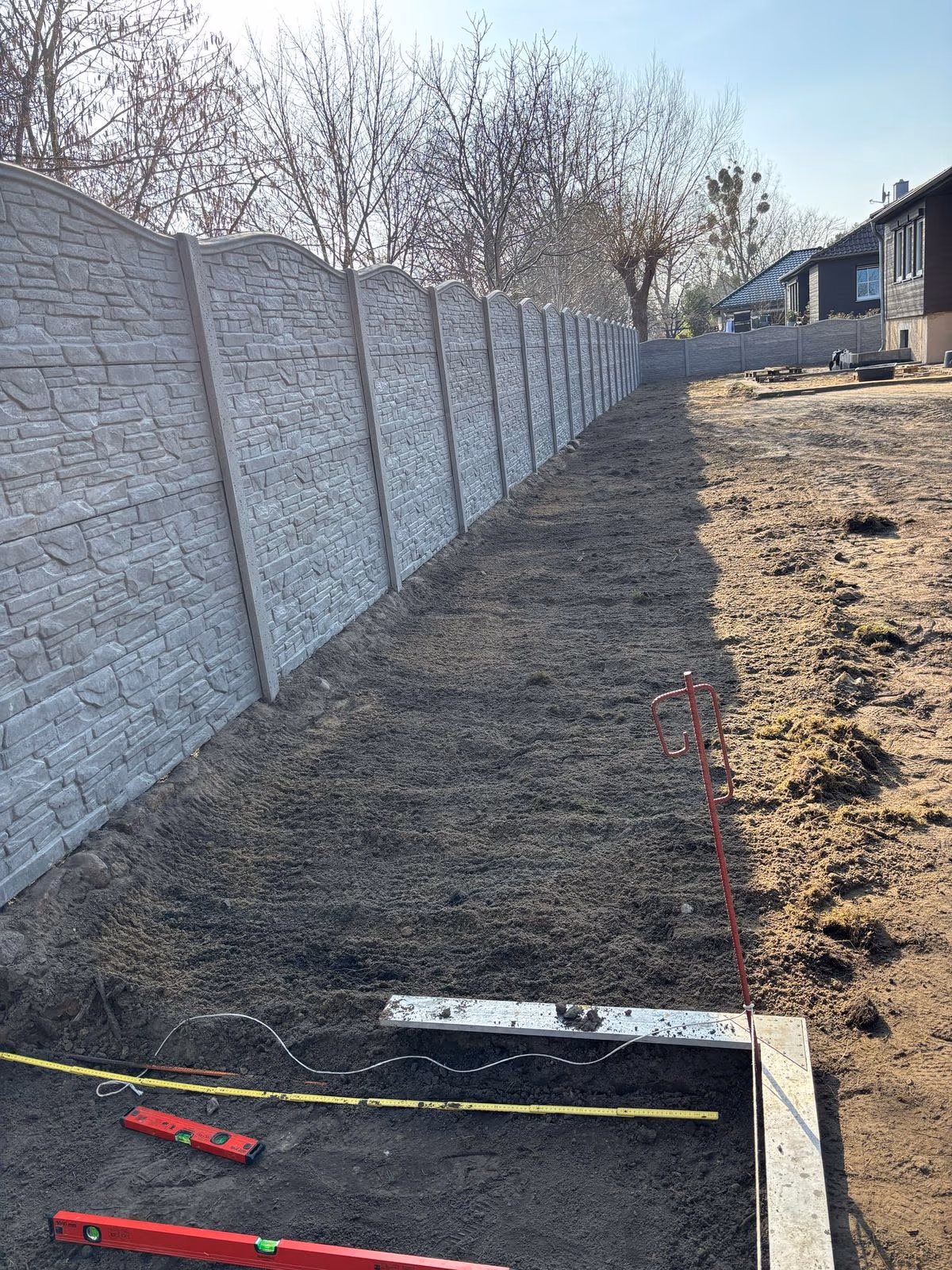 Betonzaun als massiver Sichtschutz entlang der Grundstücksgrenze