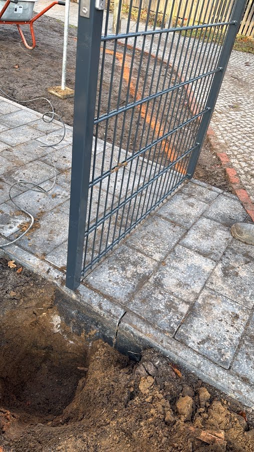 Doppelstabzaun-Pfosten frisch im Betonfundament gesetzt