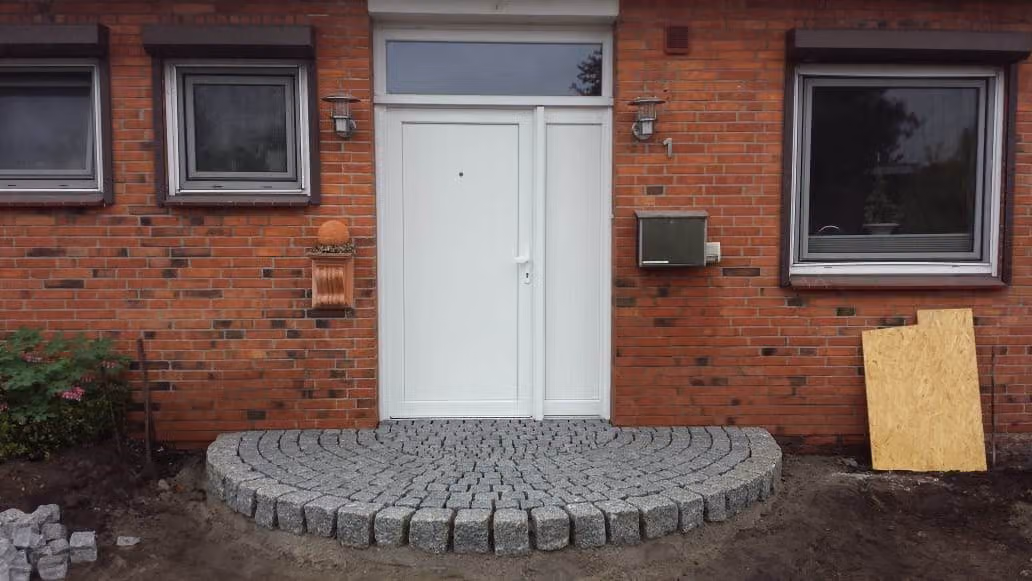 Fertiges Eingangspodest aus Granit-Kleinpflaster in Bogenform