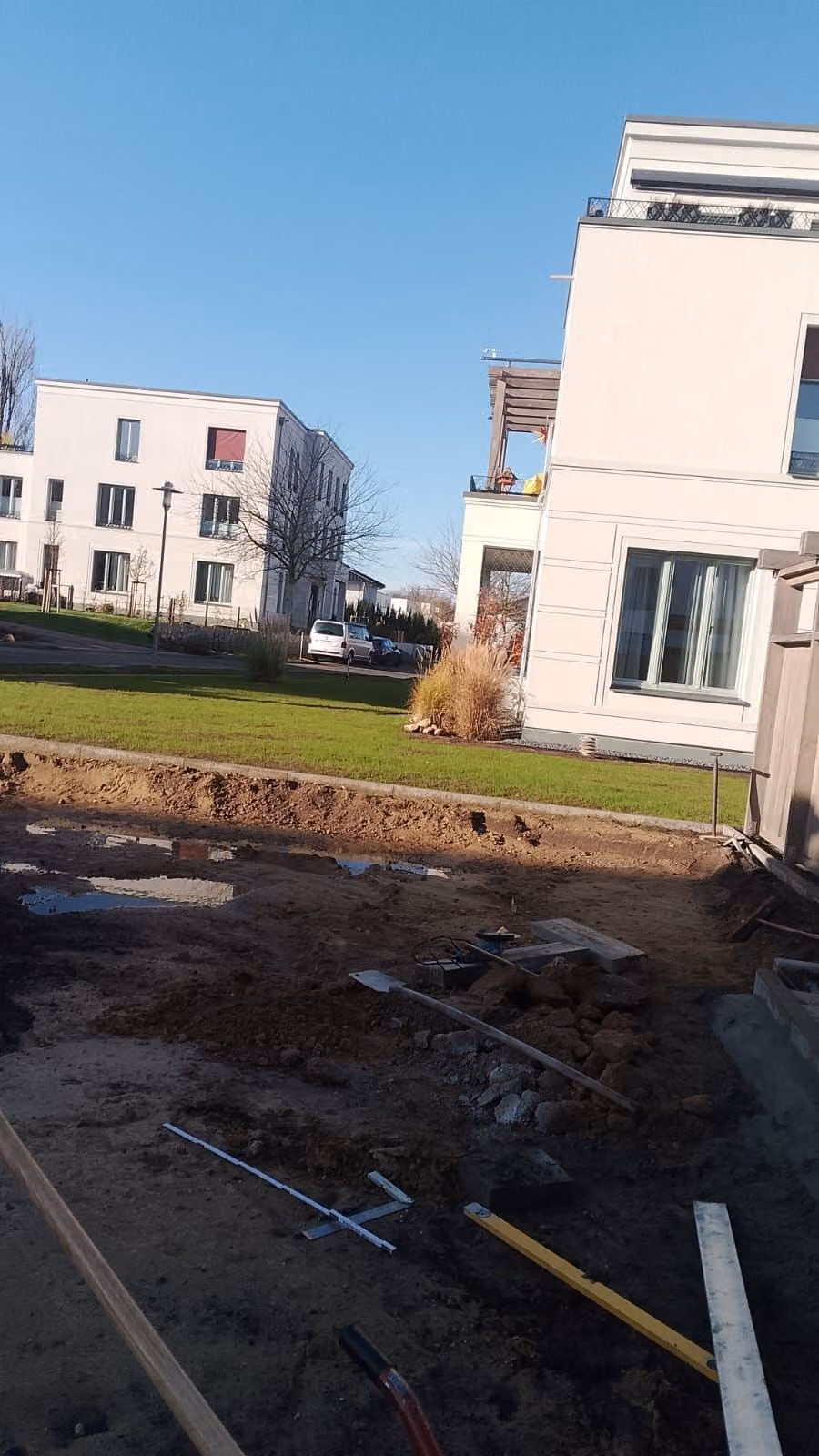 Erdarbeiten an der Außenanlage eines Neubaus mit Bordanlage und Rasenfläche