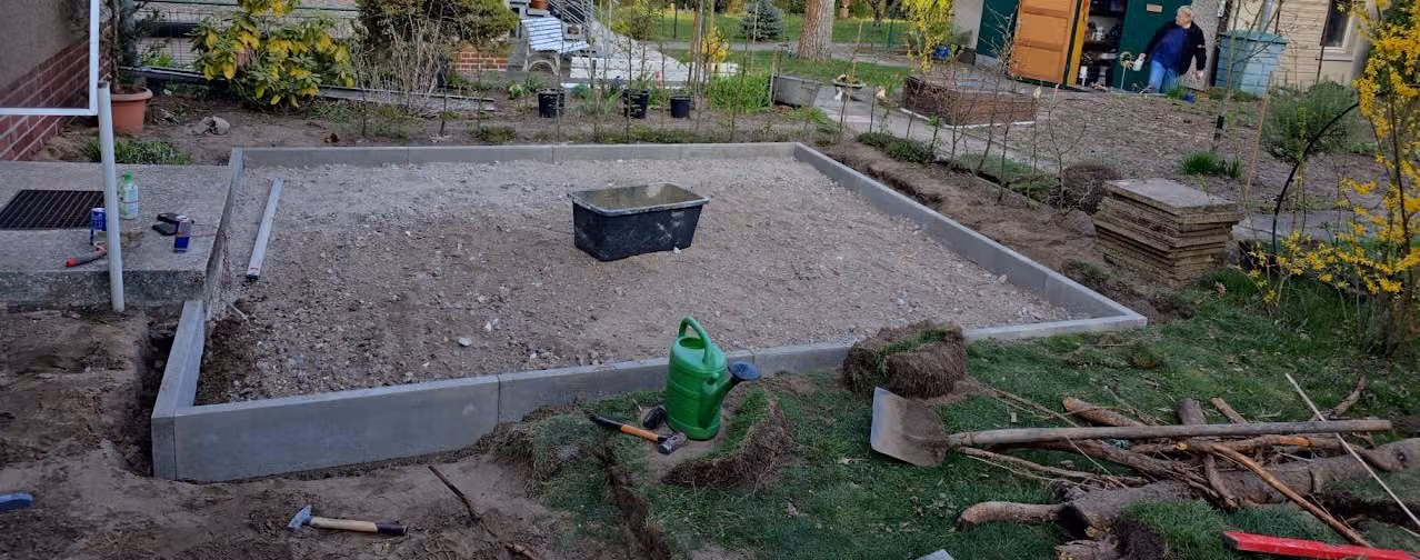 Übersicht der Gartenbaustelle mit bereits gesetzten Einfassungen und vorbereitetem Planum