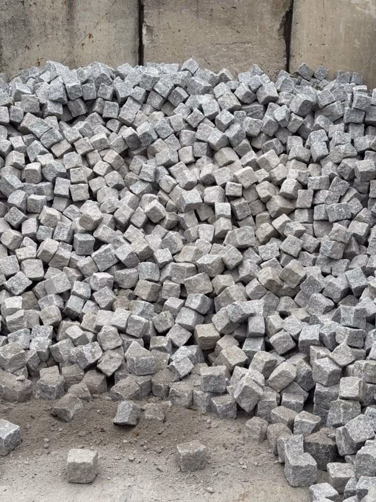 Granit-Kleinpflaster geschüttet in einer Betonbox am Materiallager