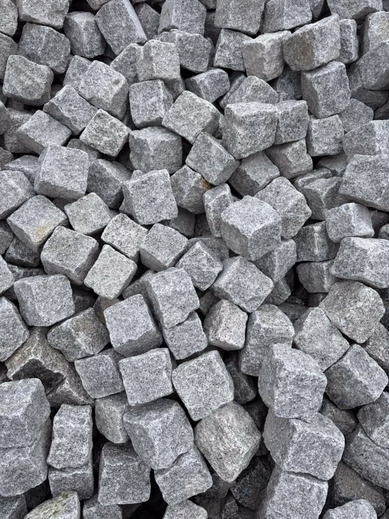 Granit-Kleinpflaster im Lager, gespaltene Steine in gleichmäßiger Körnung