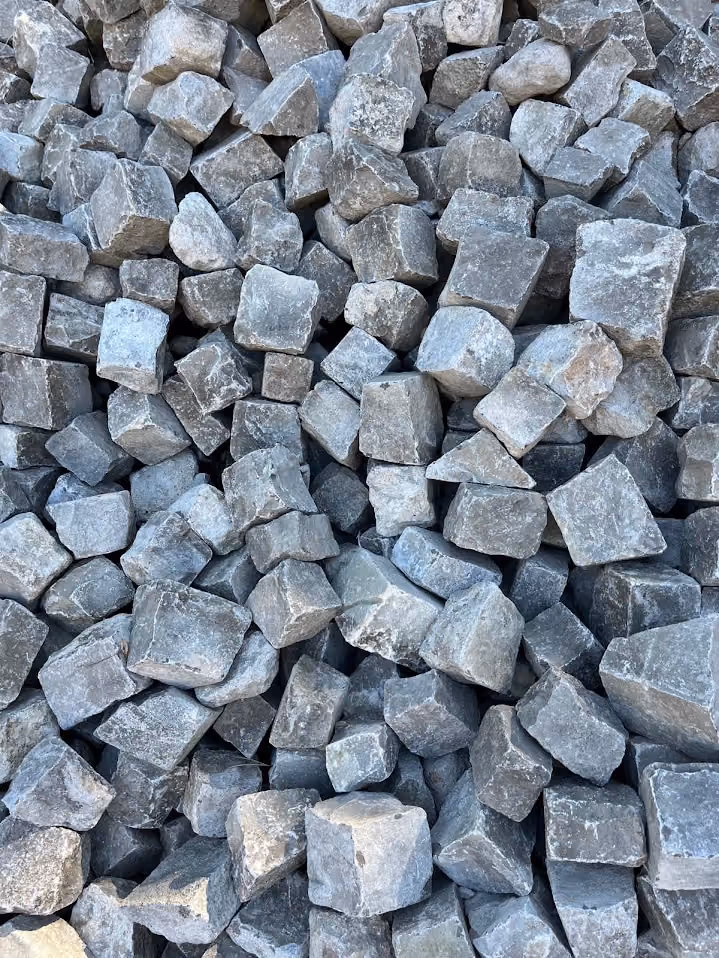 Haufen aus gespaltenem Granit-Kleinpflaster als Material auf der Baustelle