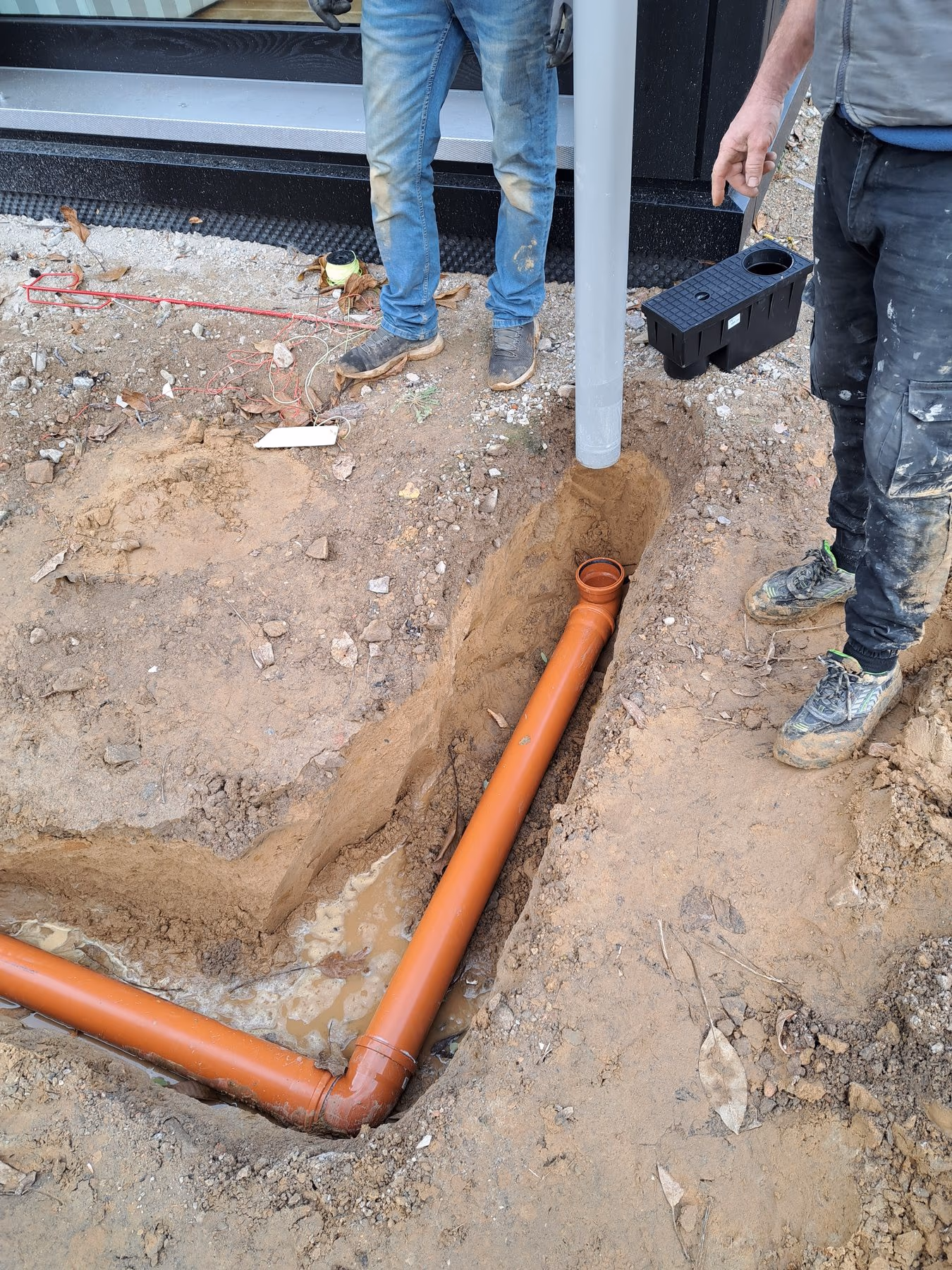 Verlegte Leitung im Graben wird vor dem Verfüllen eingemessen