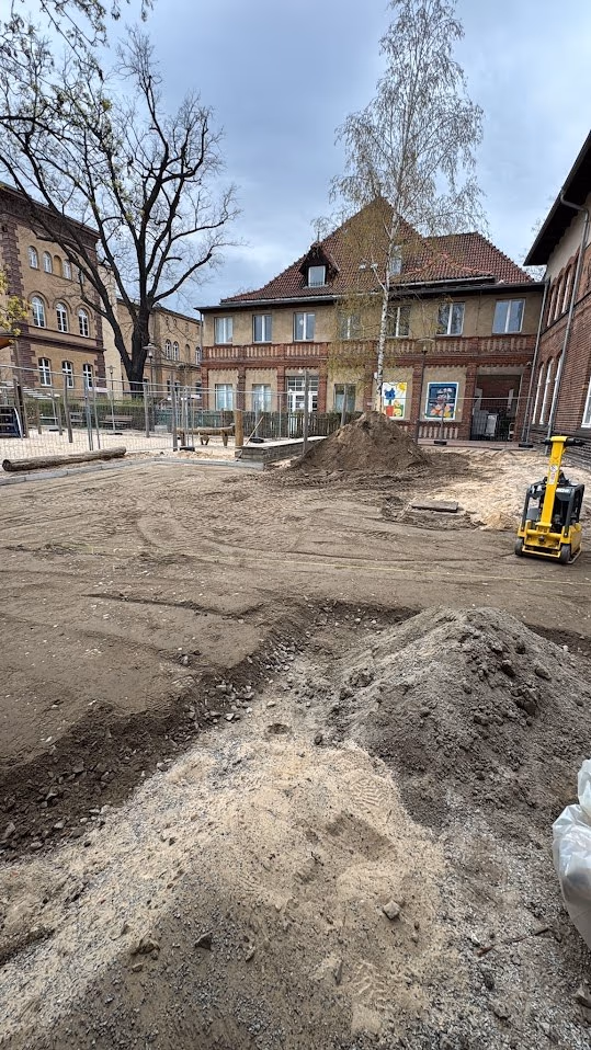 Erdaushub der alten Hoffläche mit dem Minibagger, Boden zum Abtransport aufgesetzt