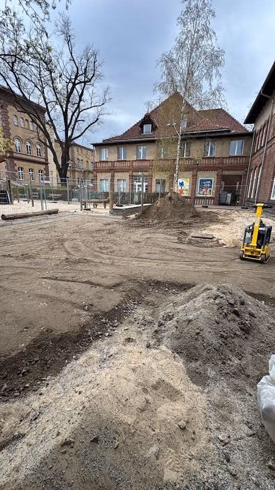 Erdaushub der alten Hoffläche mit dem Minibagger, Boden zum Abtransport aufgesetzt
