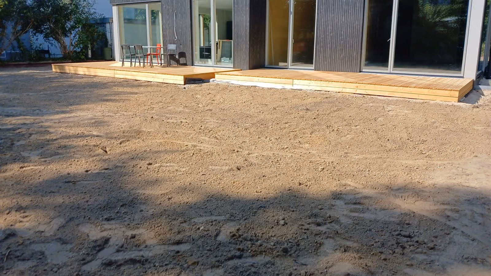 Fertige Holzterrasse mit angrenzendem abgezogenem Planum im Hausgarten