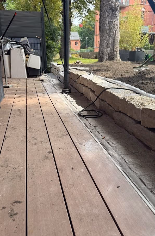 Anschluss der Holzterrasse an die Kalksteinmauer, Höhen sauber aufeinander abgestimmt