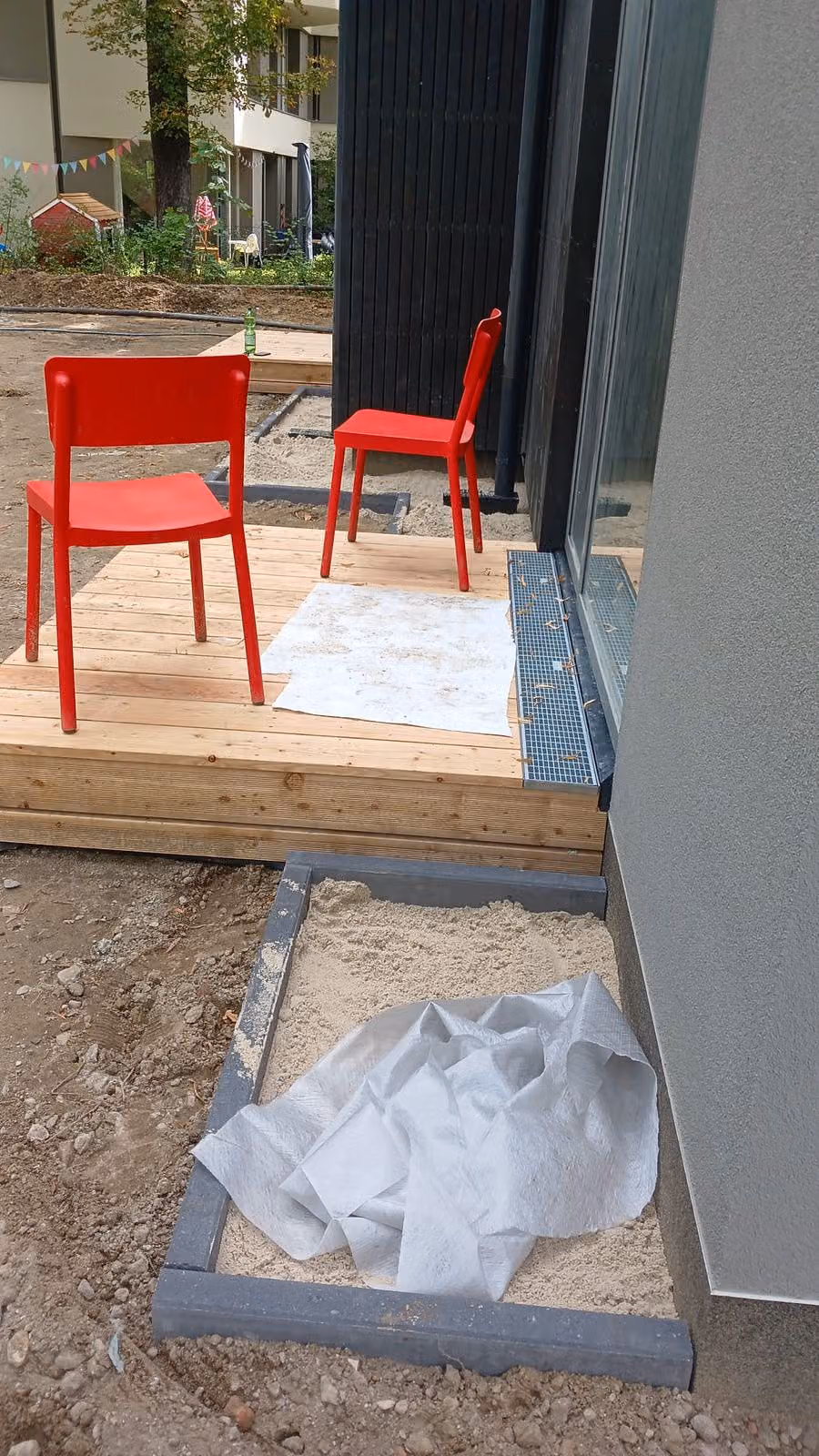 Holzterrasse aus Lärche mit Entwässerungsrinne vor der bodentiefen Tür