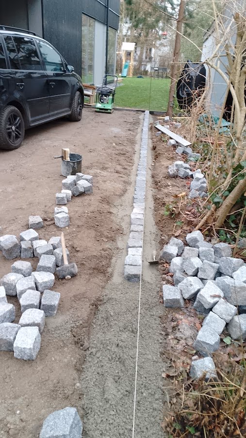 Rinne aus Granit-Kleinpflaster entlang der Zufahrt, an der Schnur ausgerichtet