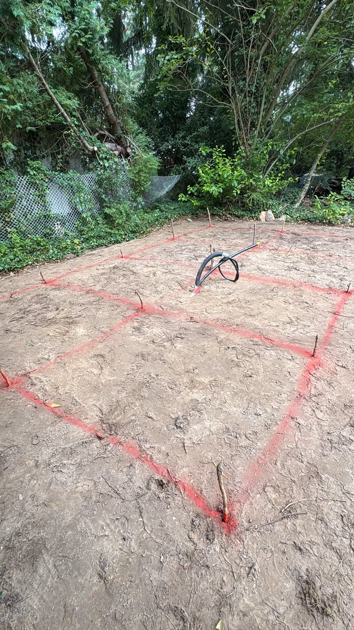 Mit rotem Schnurgerüst abgesteckte Terrassenfläche auf dem Rohplanum vor dem Aushub