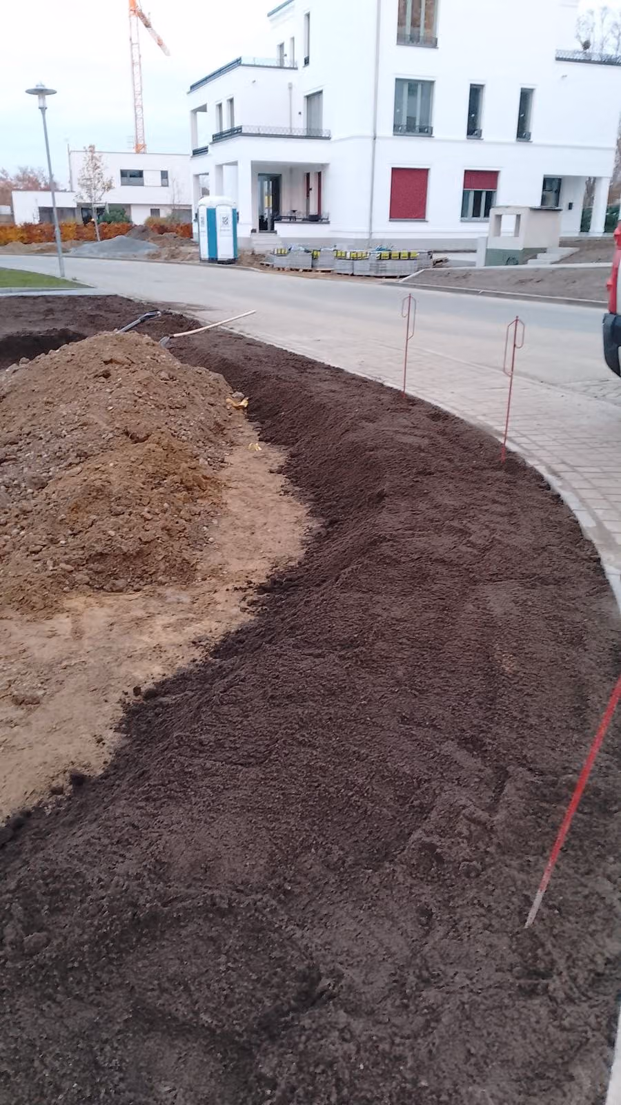 Zur Straße hin ausgeformte Oberbodenfläche mit Bordanlage im Neubaugebiet