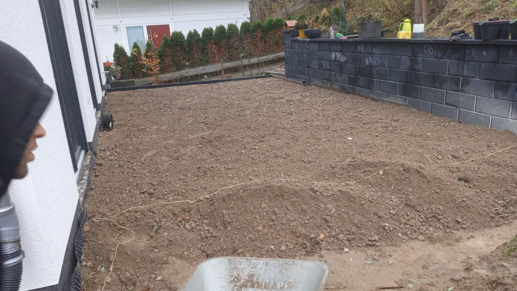 Eingebaute Tragschicht für eine Terrasse im Hausgarten vor dem Abziehen