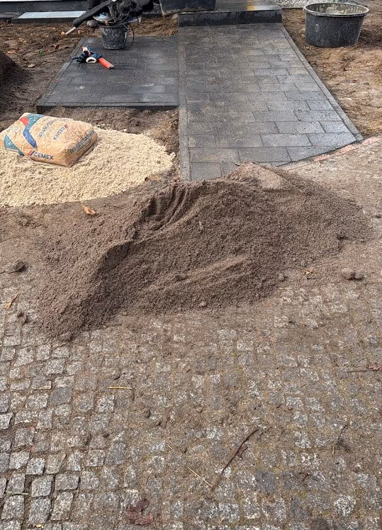 Fugenmaterial wird nach dem Verlegen in eine Pflasterfläche eingekehrt