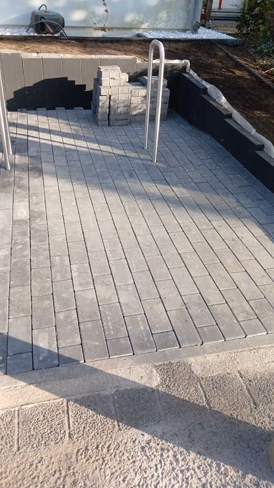 Fertig verlegte Pflasterterrasse mit sauberer Randzeile und Palisadeneinfassung