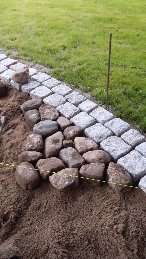 Randeinfassung aus grauem Granitpflaster und braunem Naturstein, im Sandbett an der Schnur gesetzt