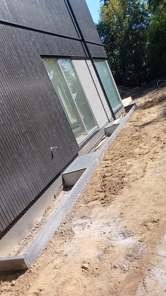 Kantenstein als Randeinfassung an der Fassade, daneben die vorbereitete Fläche