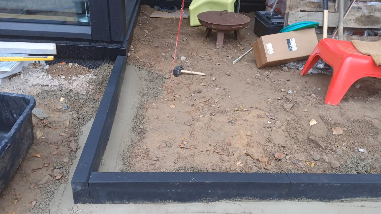 Fertig gesetzte Randeinfassung im Mörtelbett um eine künftige Terrassenfläche