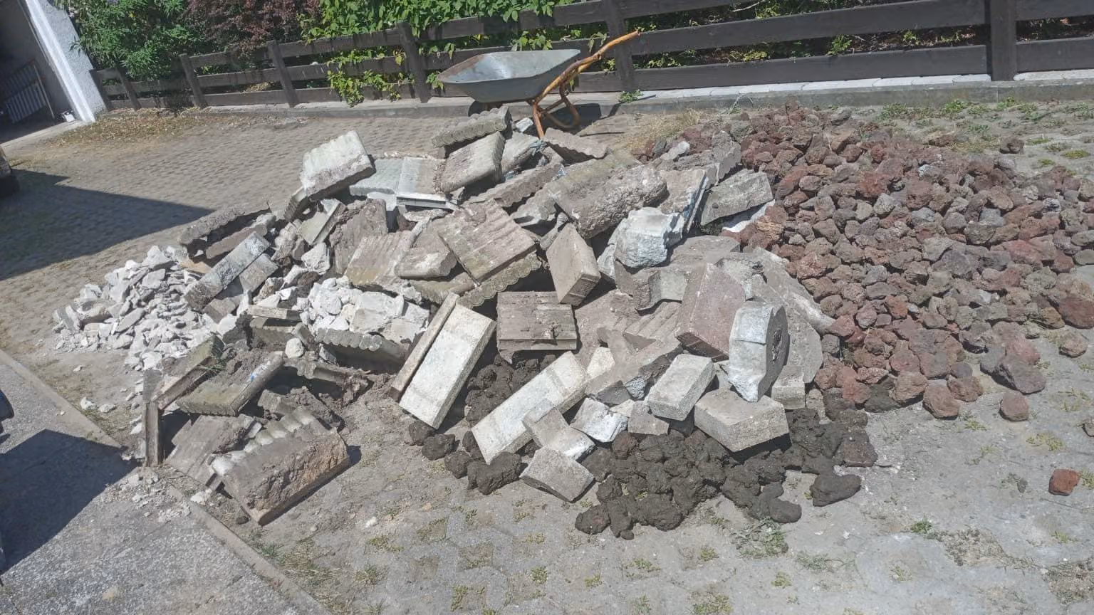 Abbruchmaterial sortenrein getrennt: Betonplatten neben Lavasteinen zur Entsorgung