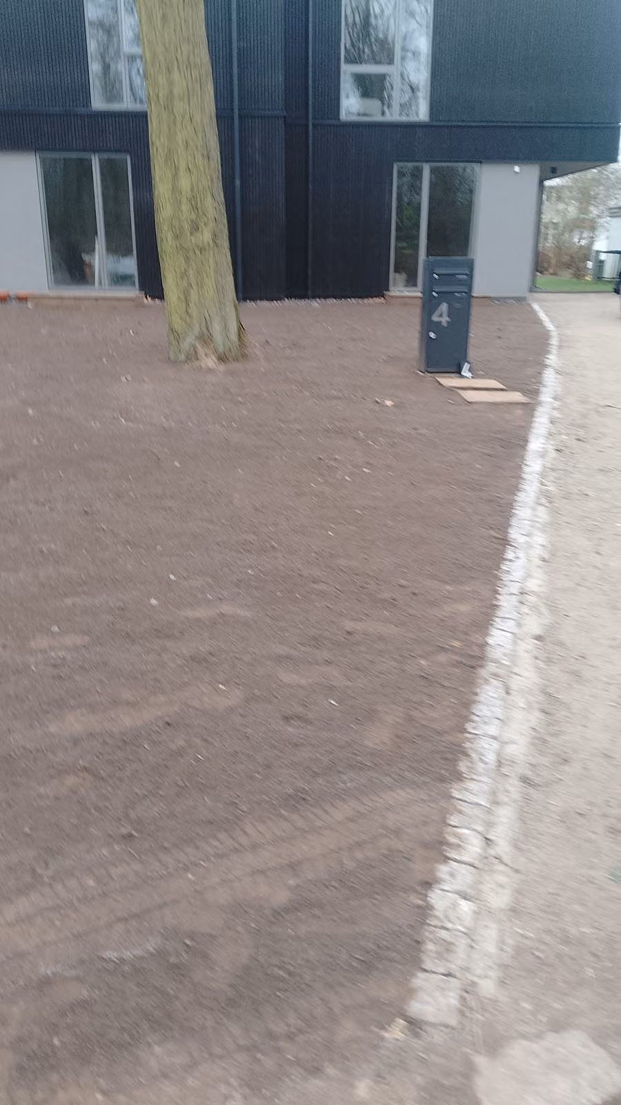 Abgezogenes Planum am Neubau, begrenzt von einer Granit-Kleinpflasterkante