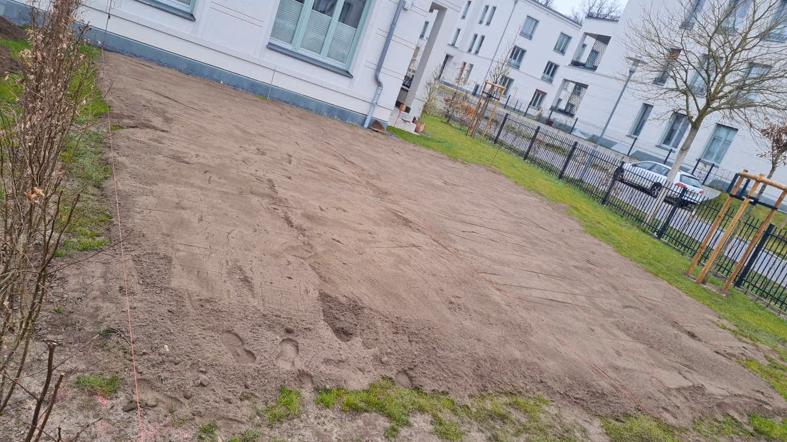 Abgezogenes Sandplanum der künftigen Rasenfläche an einer neuen Wohnanlage