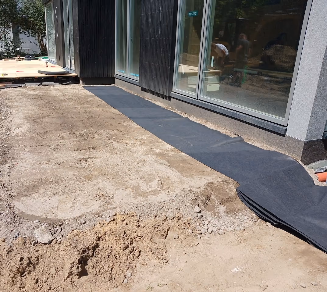 Ausgelegtes Trennvlies entlang der Fassade vor dem Aufbau der Terrasse