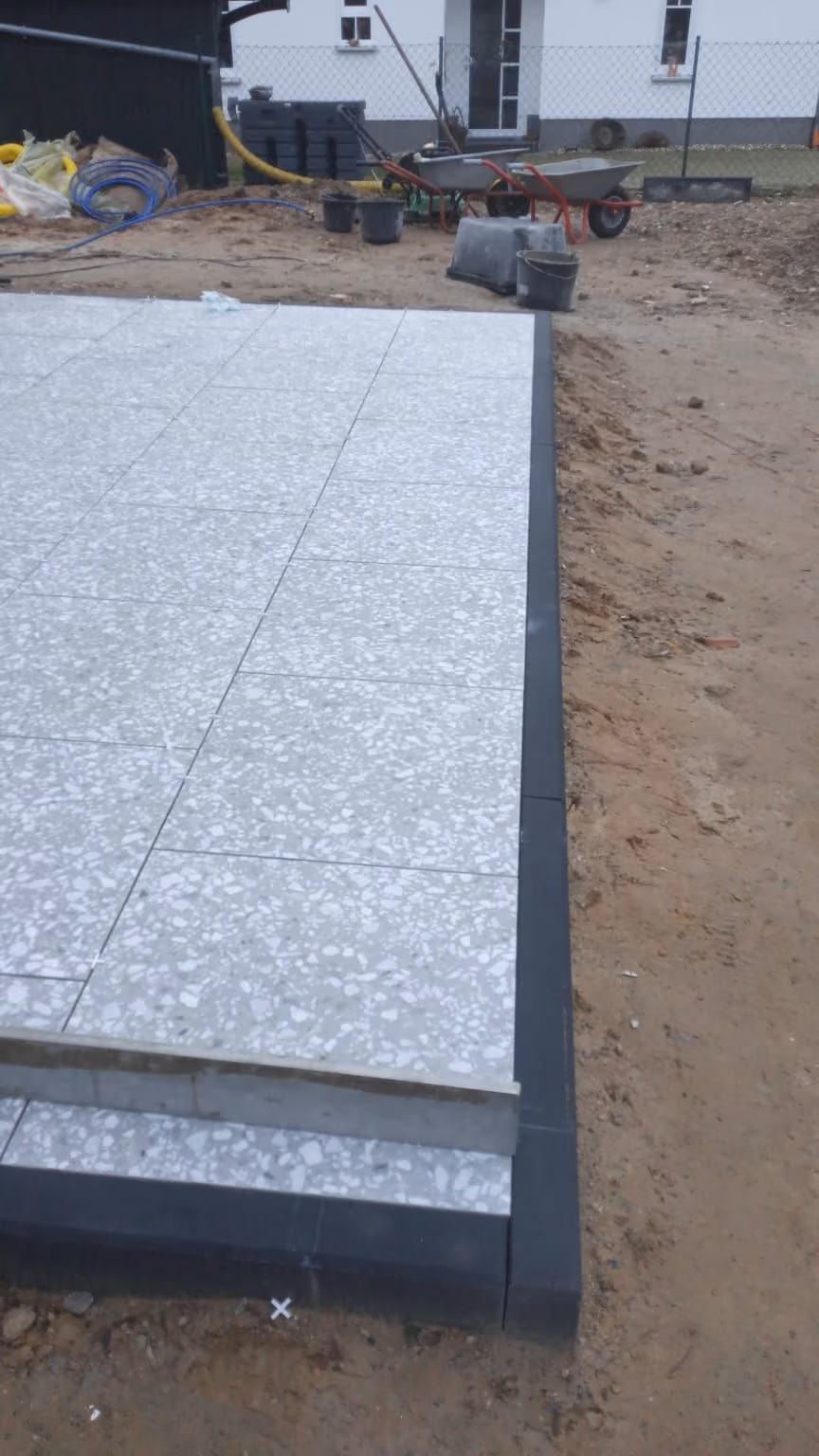 Detail der Terrassenkante: Randstein bündig zur Plattenoberkante gesetzt