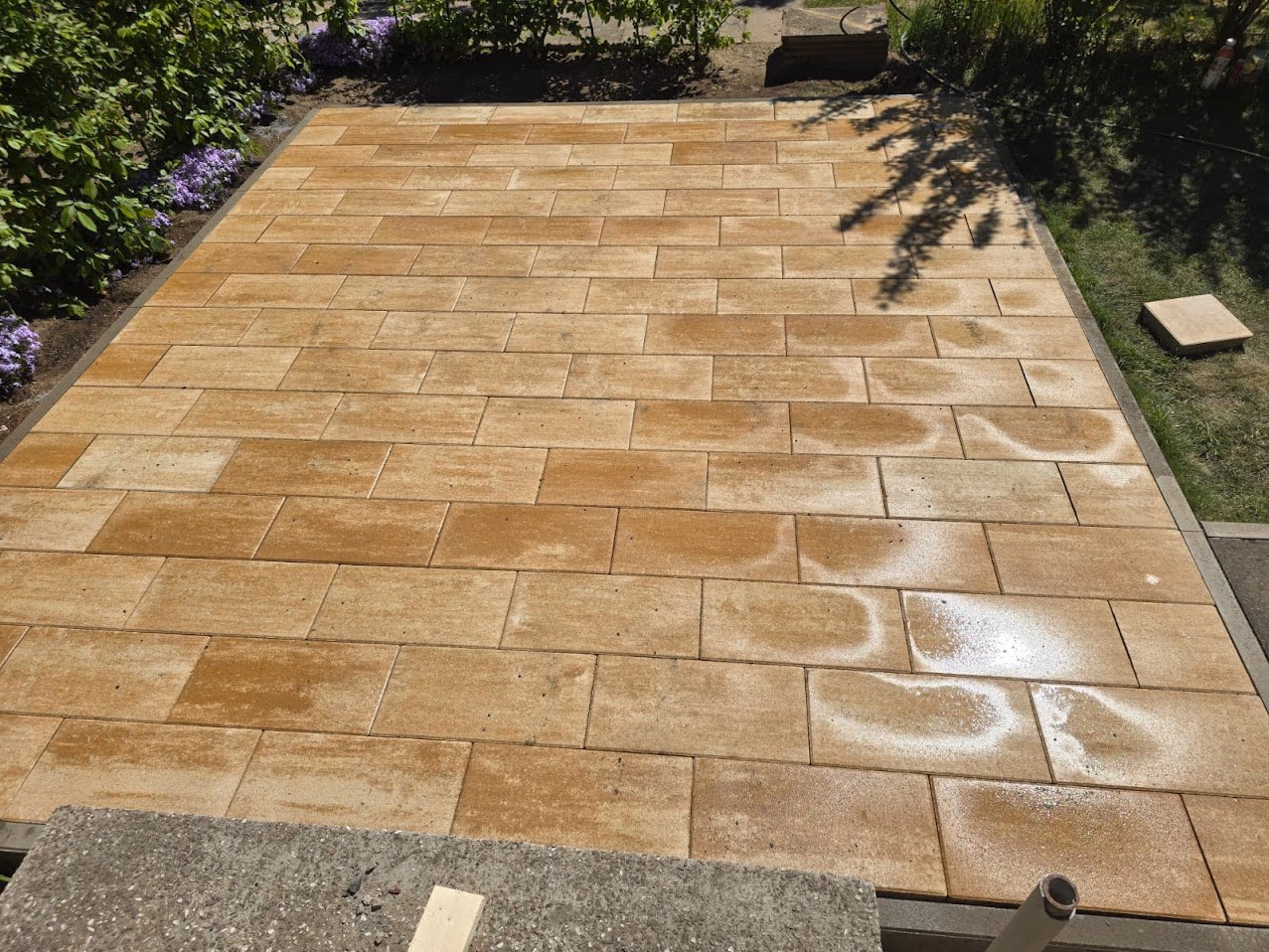 Fertig verlegte Terrasse aus großformatigen Platten in Sandsteinoptik im Läuferverband