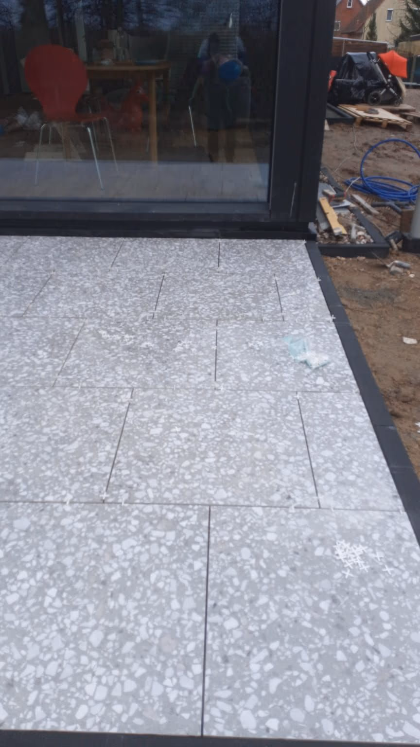 Fertige Terrazzoterrasse mit anthrazitfarbener Randeinfassung am Wohnhaus