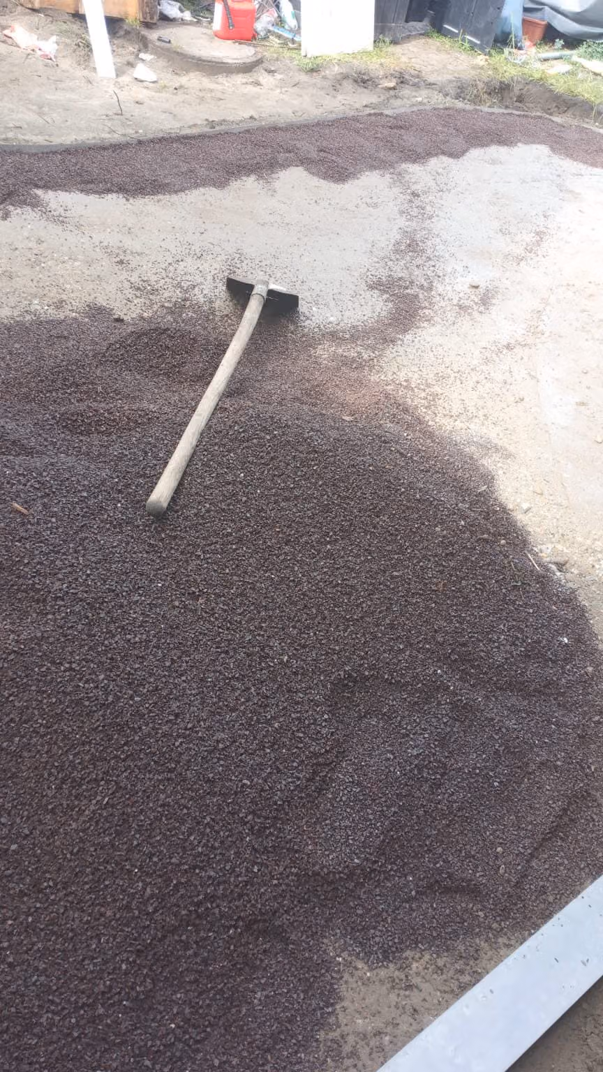 Bettungsmaterial wird beim Terrassenprojekt mit der Harke verteilt und abgezogen