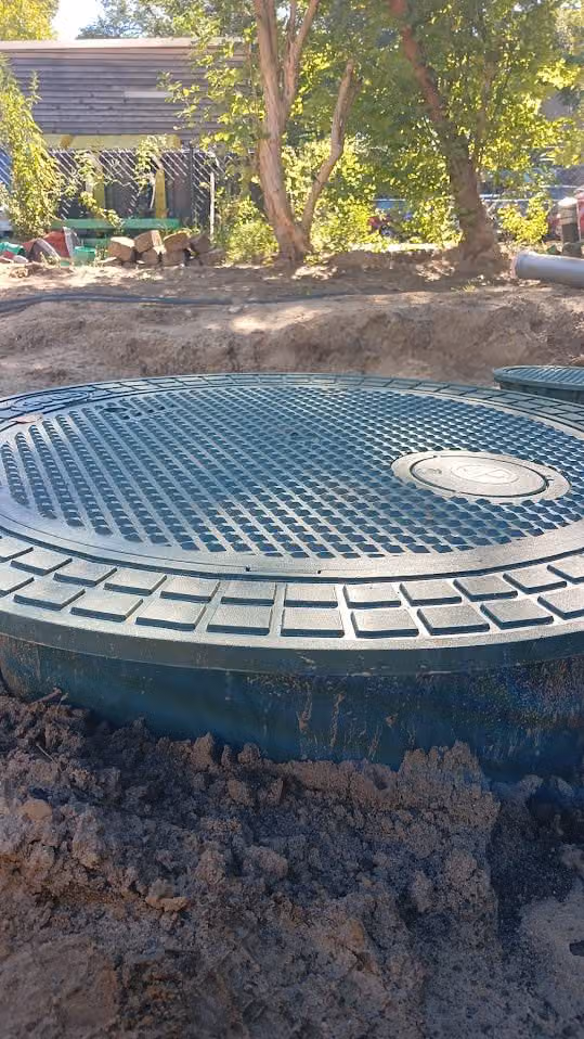 Begehbarer Deckel auf dem Domschacht einer eingebauten Zisterne im Garten